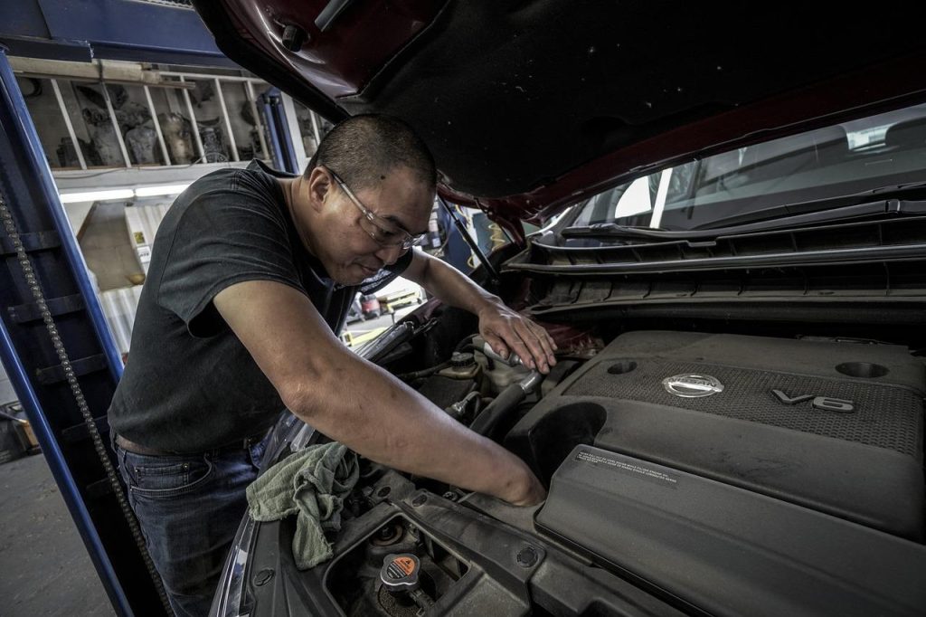 Auto reparatie in Maastricht: deskundige monteur inspekteert voertuig in professionele werkplaats